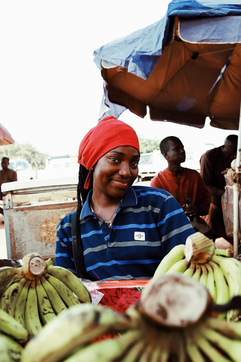 A smiling plantain seller at a Nigerian market